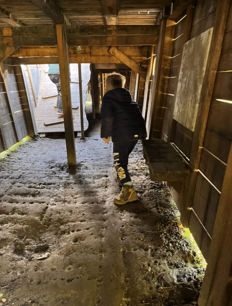 Kind erkundet das Unterdeck der hölzernen Arche
